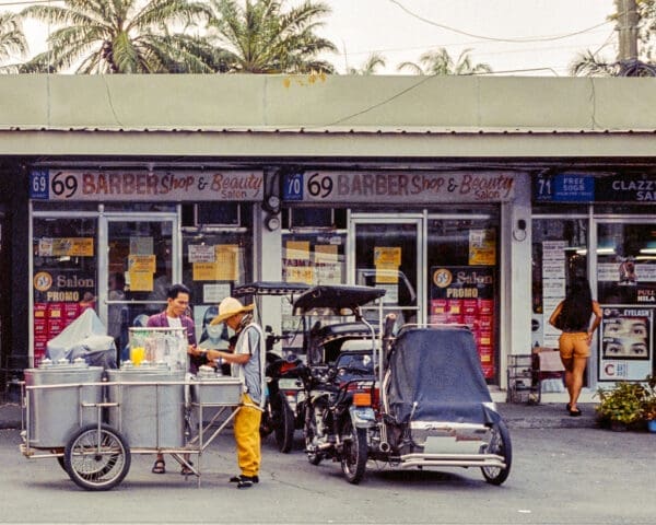 Street vendor and barbershop scene in tropical Philippines.