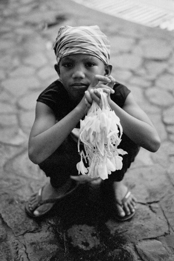 Young Filipino boy selling sampaguita flowers, a significant cultural symbol, in Pampanga, Philippines.