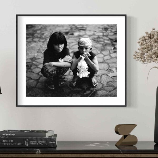 Framed Black and White Print of Young Siblings on Minimalist Shelf in Modern Interior.