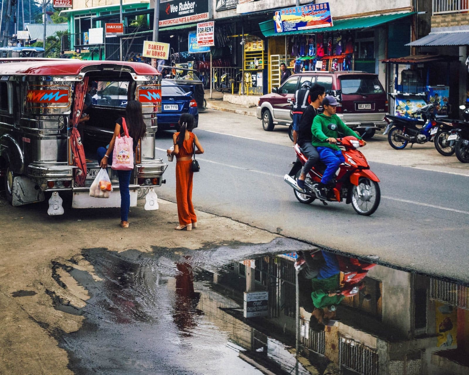 Vibrant Philippine street scene with jeepney and motorcycle.