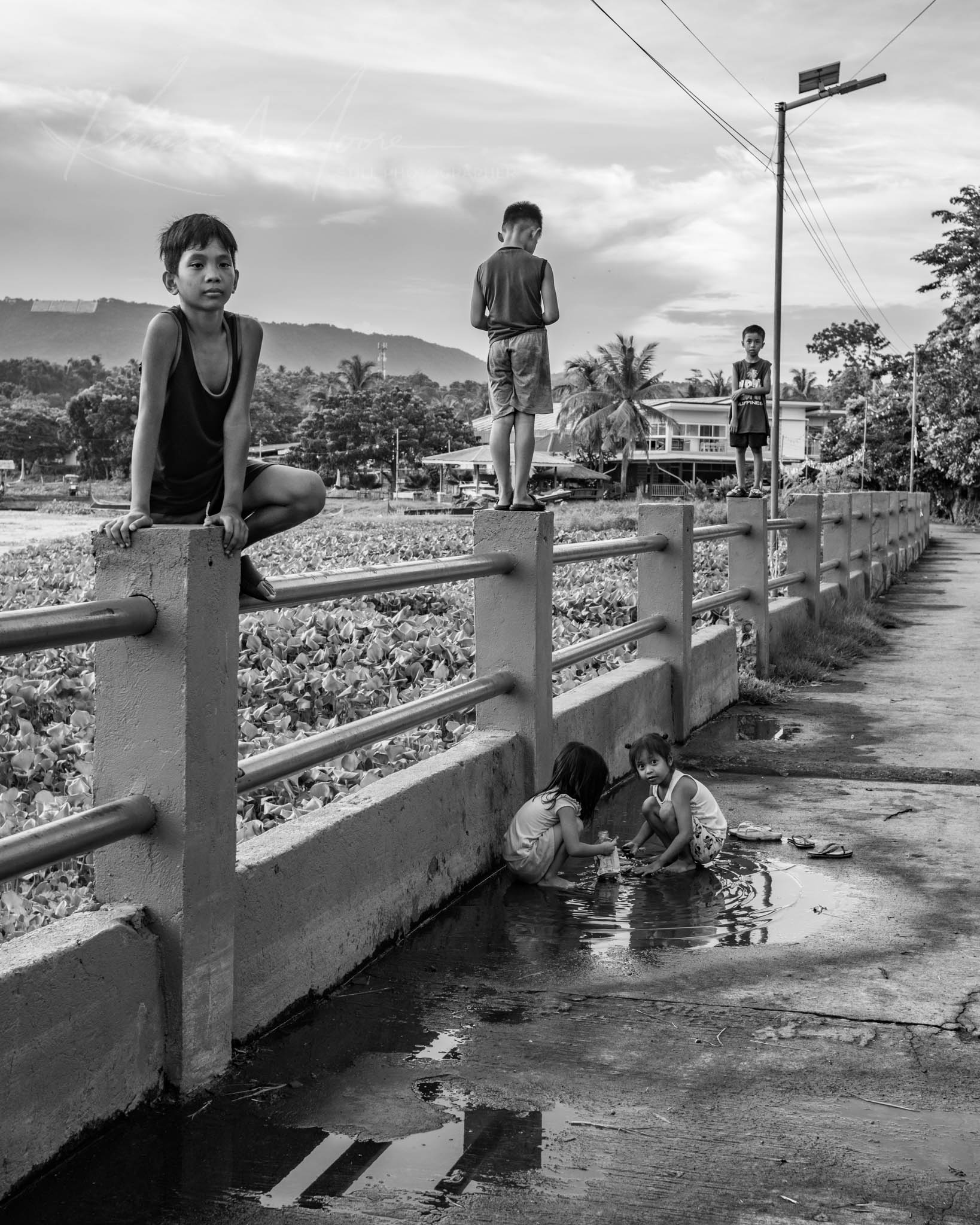 Filipino children playing in rain puddles in rural Philippines.