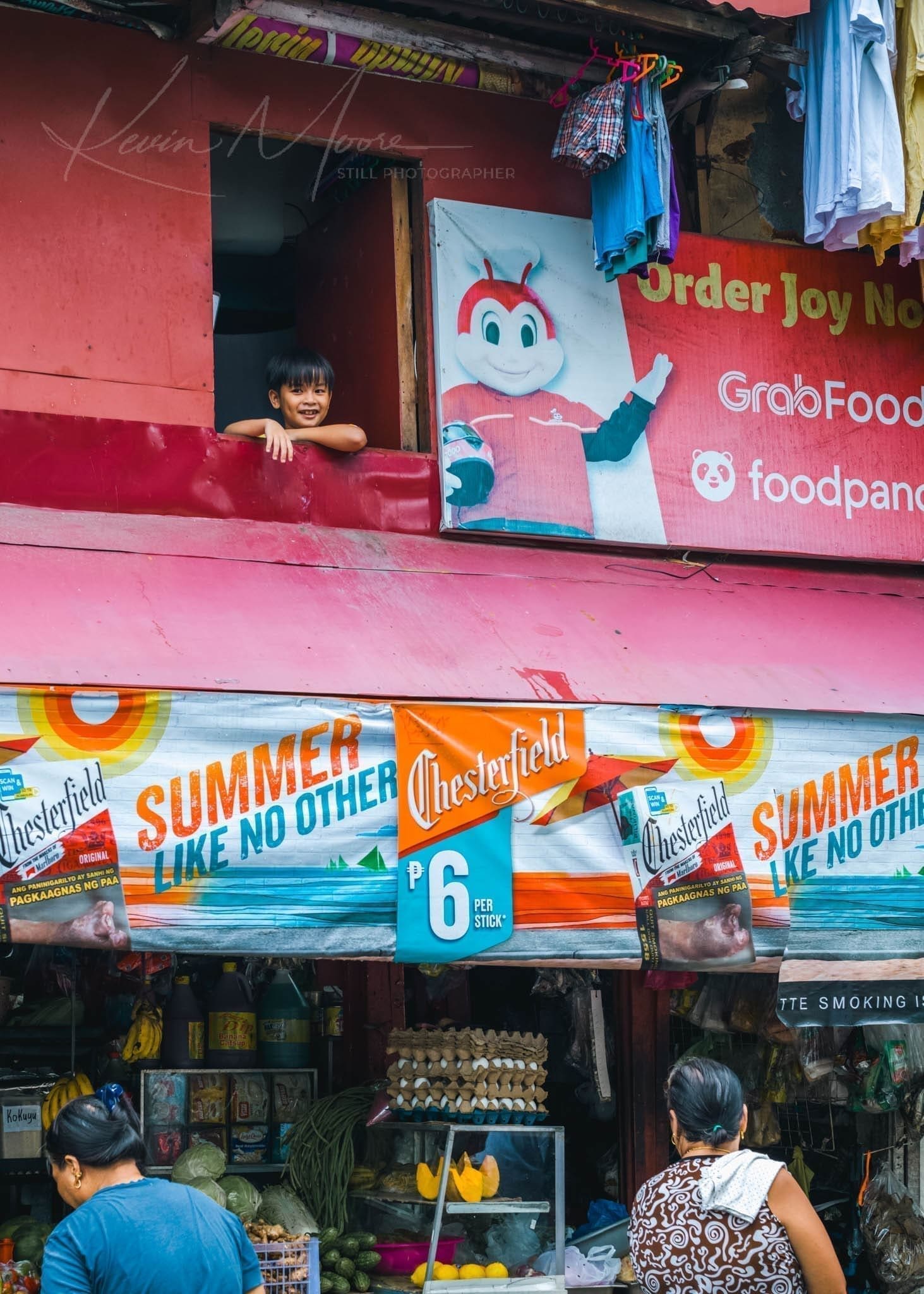 Vibrant Manila Intramuros Philippines street scene with colorful storefront and happy child.