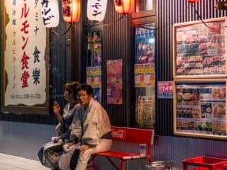 Couple relaxing at traditional Izakaya on a quiet Japanese street at night