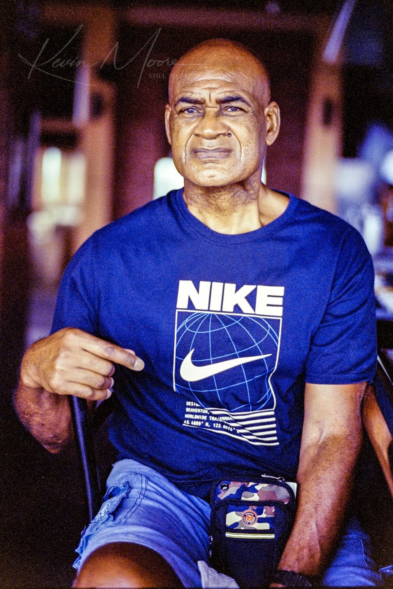 Middle-aged man in Nike shirt in a cafe setting.