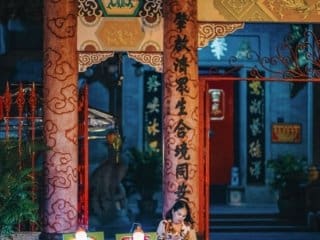 Vietnamese pho vendor at a traditional temple at night.