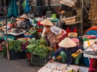 Bustling Vietnam street market with vendors selling fresh produce and local goods.