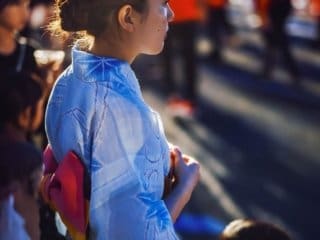 Young woman in traditional blue dress at cultural festival.