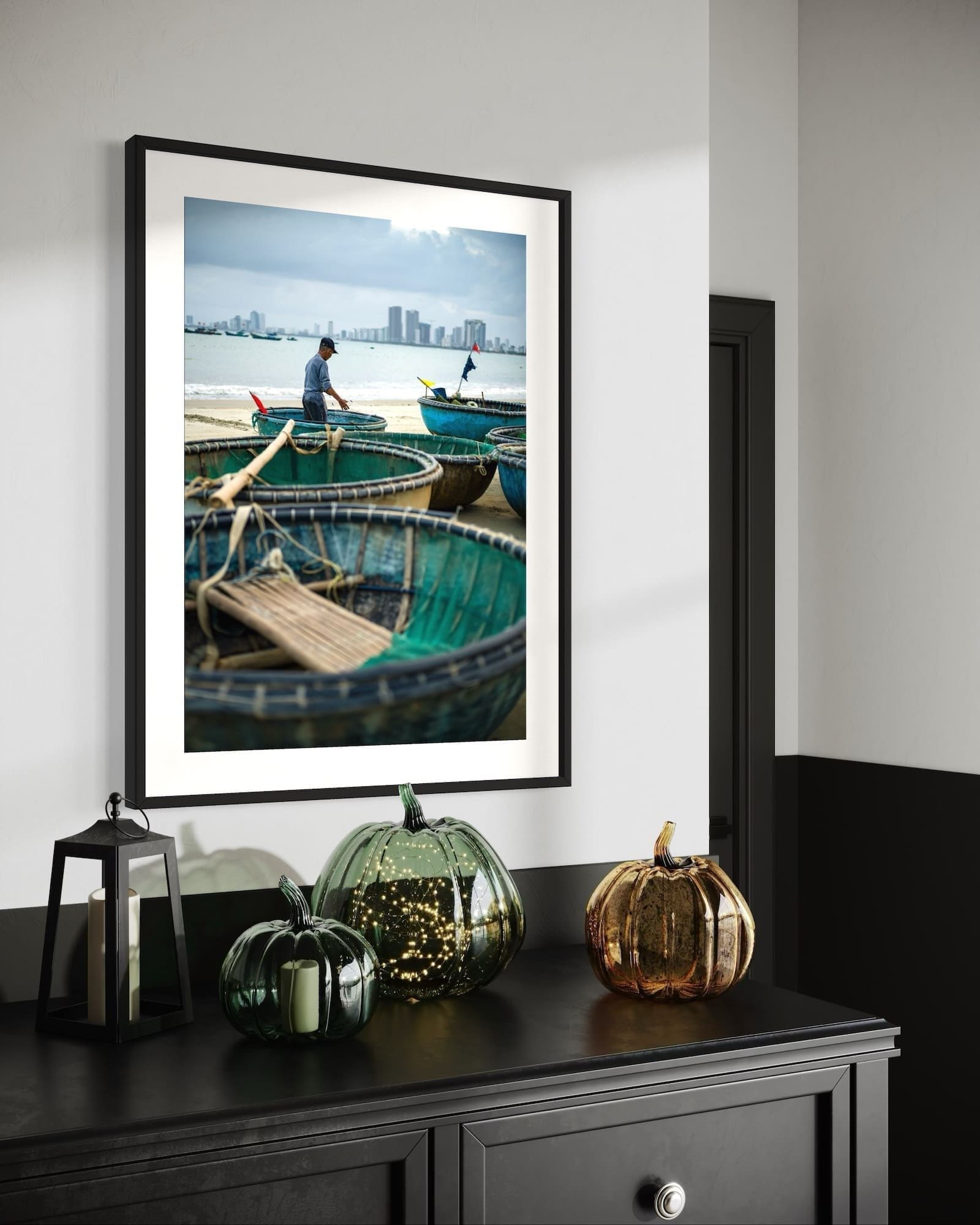 Modern dresser with seasonal decor and coastal photograph in stylish interior.