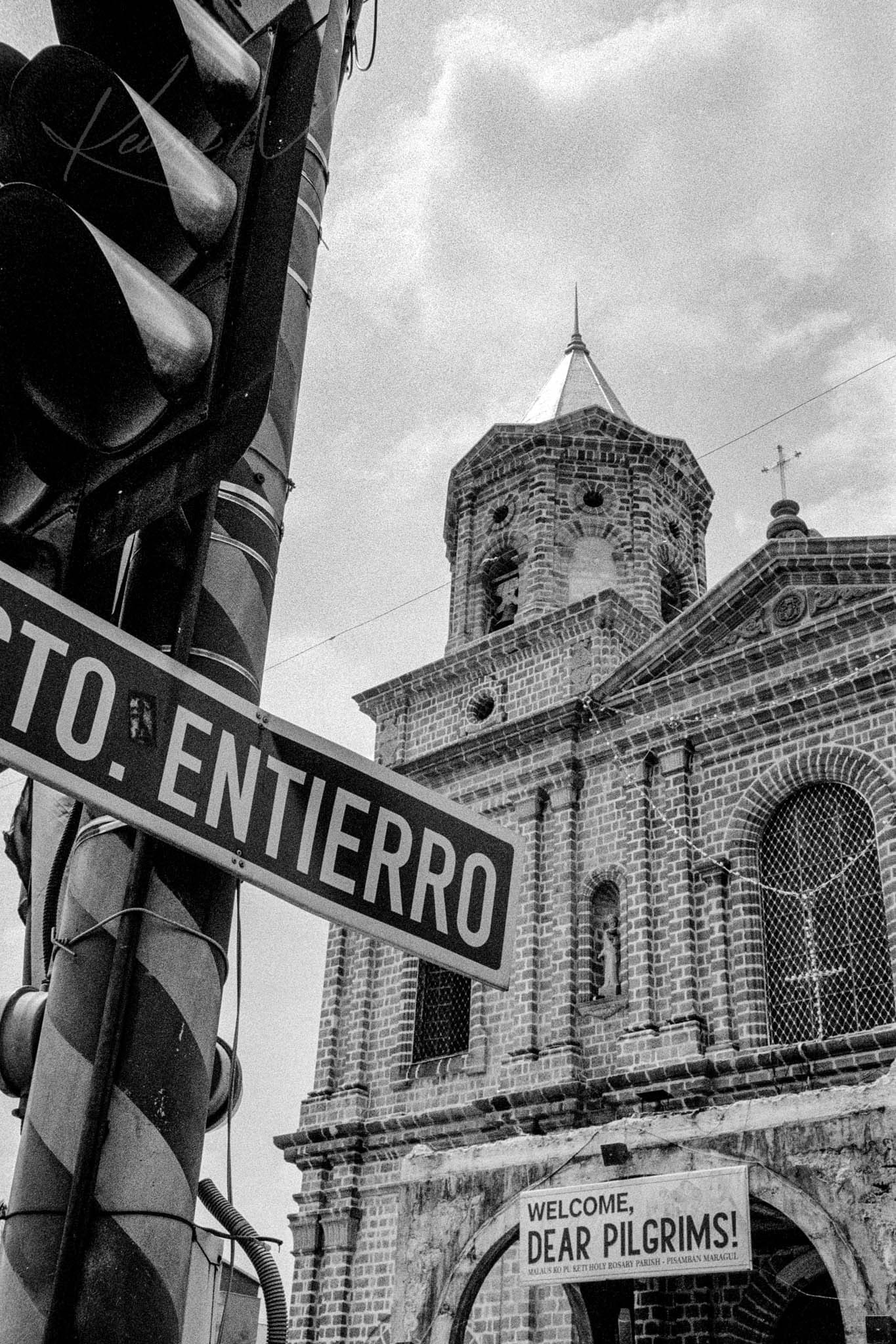 Historic cathedral with Sto. Entierro sign and pilgrim welcome banner in a Spanish region.