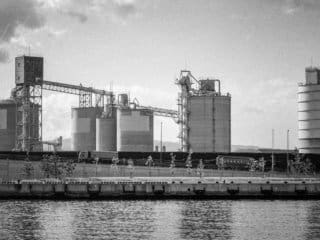 Industrial Silos and Freight Train at Riverside Factory Riverside Factory with Industrial Silos and Docked Freight Train in Black and White