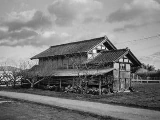 Timeless Eastern Farmhouse in Serene, Overcast Setting Old Eastern-style farmhouse in a serene, rural setting with overcast sky.