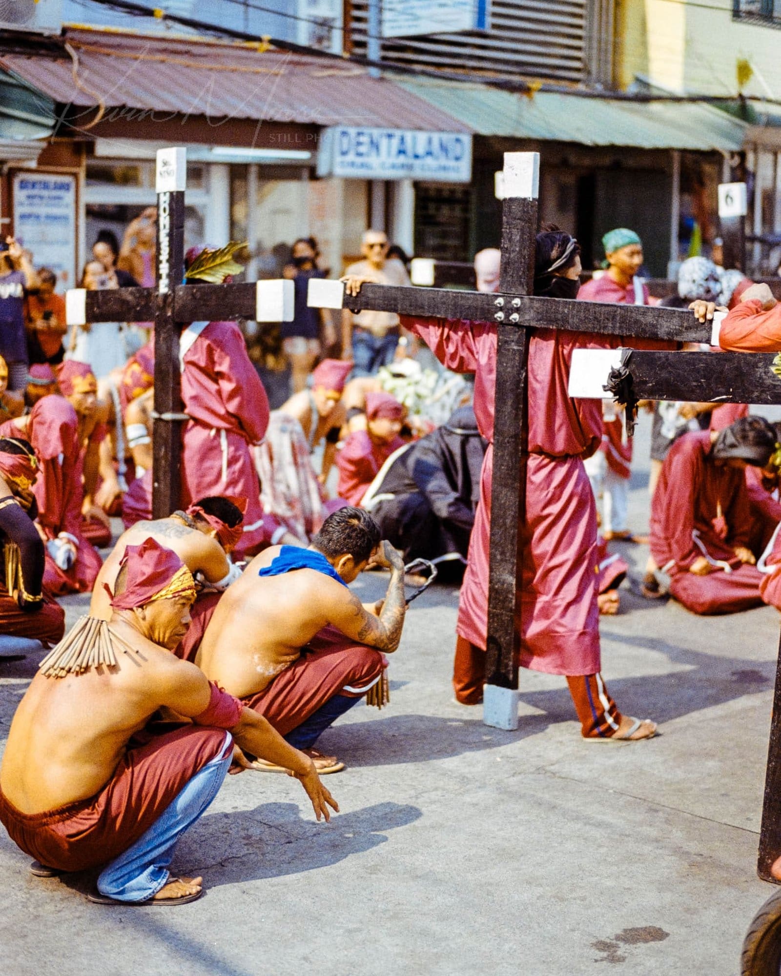 Red-robed cross bearers in a somber street procession in the Philippines