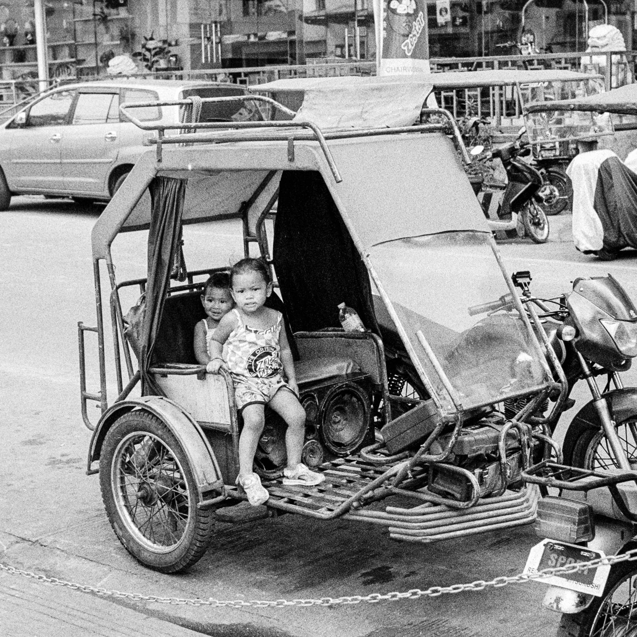 Street scene with children in a tuk-tuk in Southeast Asia.