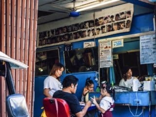 Barber attentively cuts hair of child in vibrant Philippines barber shop.