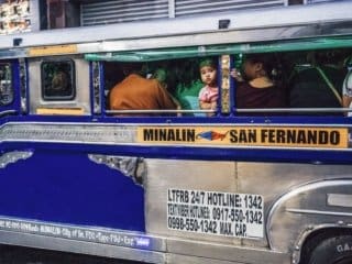Morning Commute in a Colorful Filipino Jeepney Colorful jeepney in Philippines with passengers during dawn or dusk.