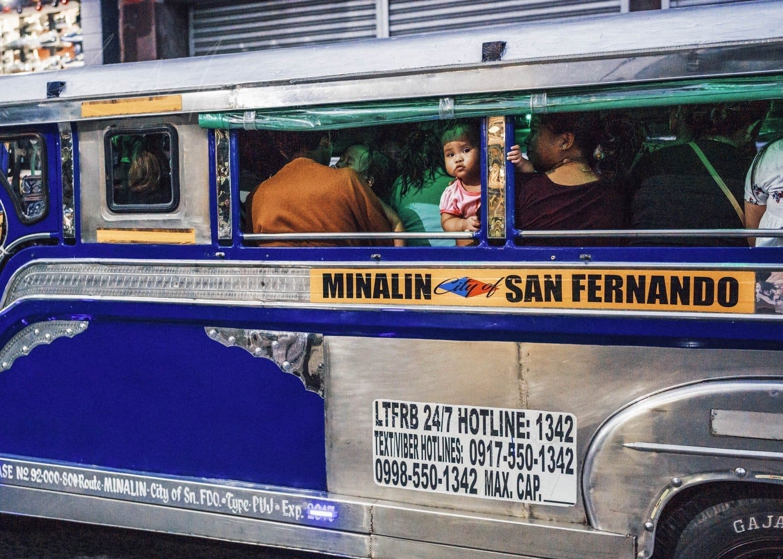Colorful jeepney with a child gazing out, representing Philippines Street Photography.