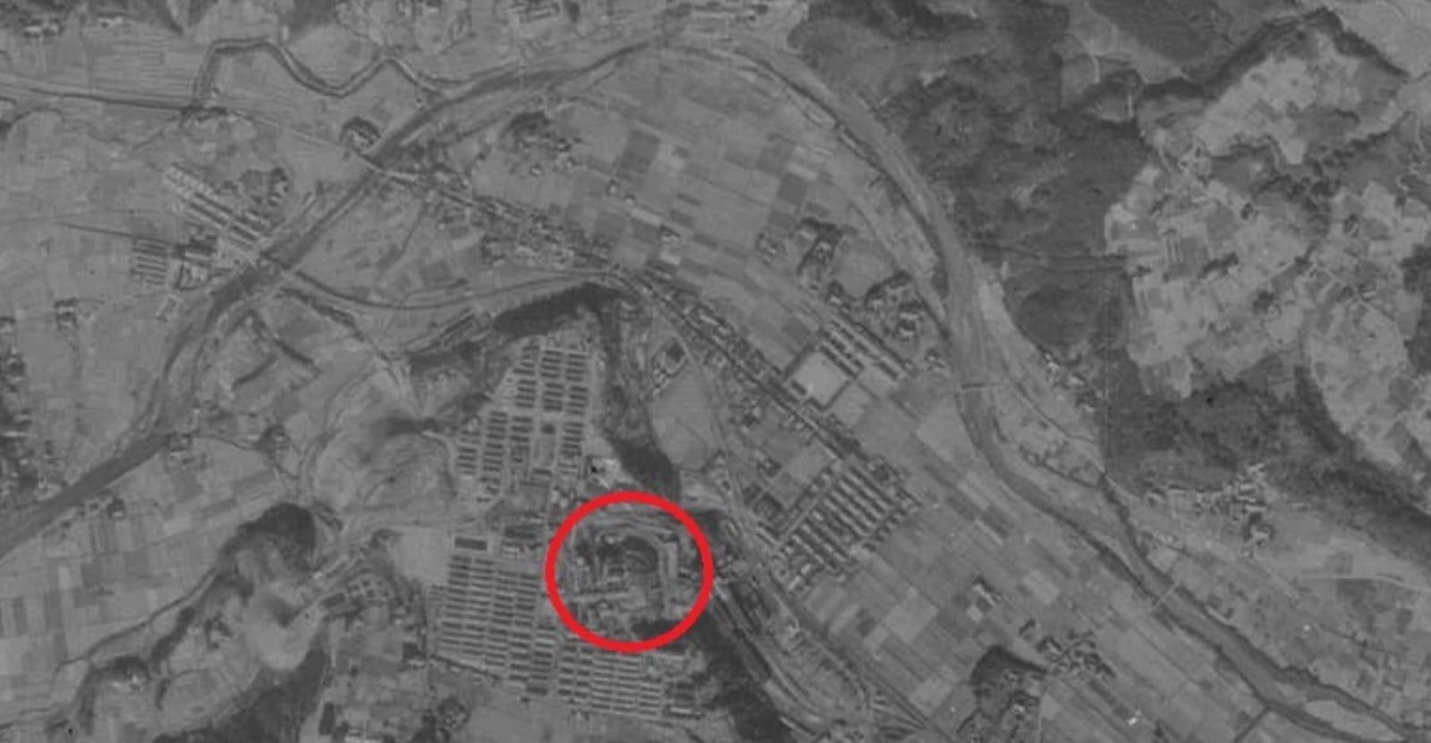 Aerial view of urban development and natural landscapes divided by river.