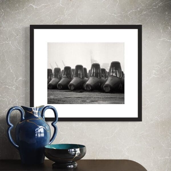 Framed fine art black and white print titled Idle Line, showing tetrapods in storage at Onahama Port, Japan