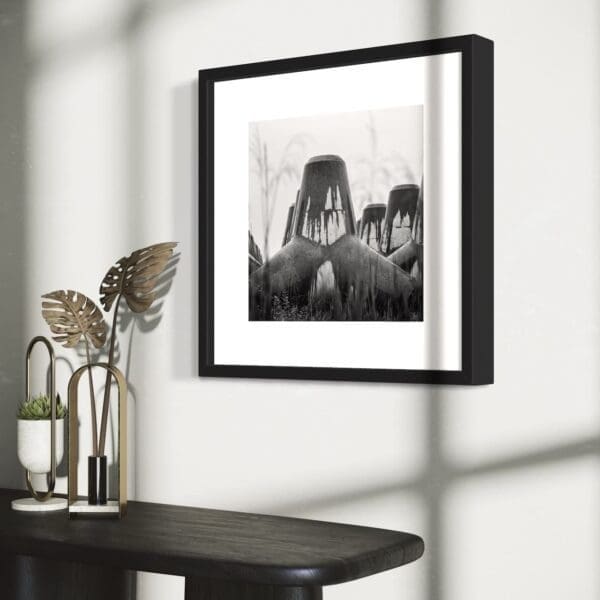 Framed fine art black and white print of tetrapods, shown from an angle with decorative objects