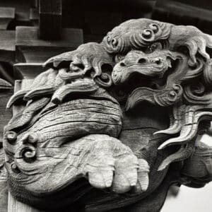 Black and white close-up of a Japanese temple carving — ornate wooden shishi guardian at Akaidake Temple, Fukushima