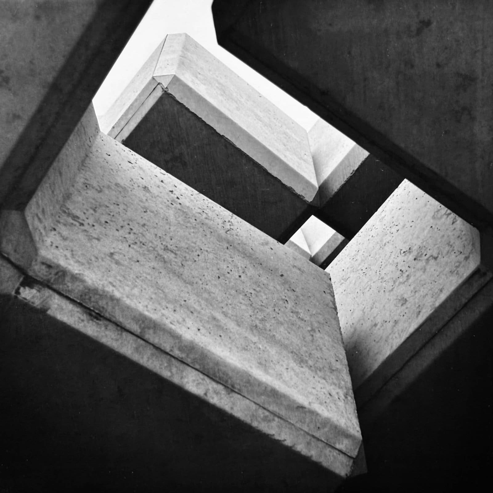 View looking up from beneath concrete tetrapod wave breakers on the Fukushima coast, Japan — black and white fine art print