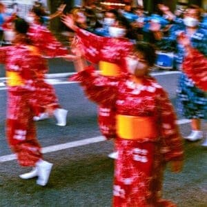 Japanese festival print: red-yukata dancers blurred in motion at a Bon Odori summer festival at night in Iwaki, Japan.